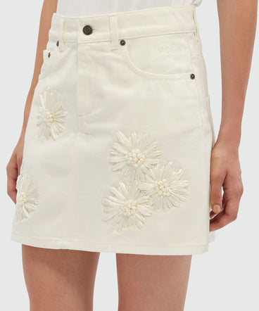 Short skirt in white denim with raffia flowers