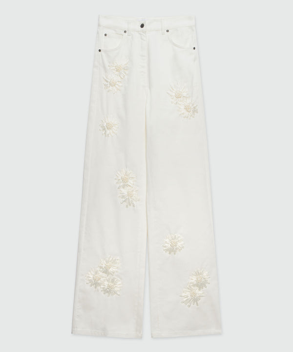 White denim trousers with raffia flowers